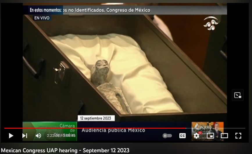 A screenshot of a YouTube video titled Mexican Congress UAP hearing - September 12 2023. It shows an object identified as a humanoid mummy inside a box. It is covered in white paste or powder and is very elongated.